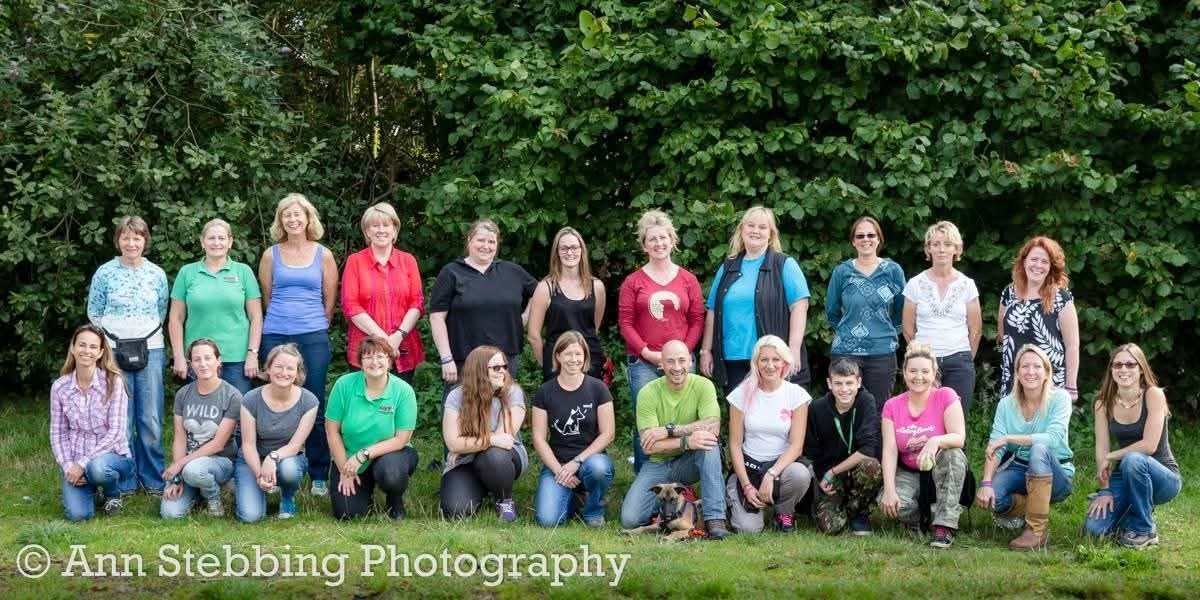 A School of Canine Science practical course group photographed outdoors with a dog